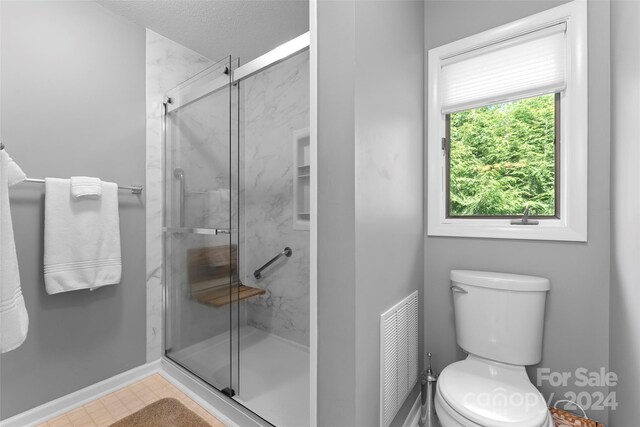 bathroom featuring an enclosed shower and toilet