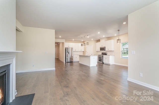 unfurnished living room featuring dark wood-type flooring and sink