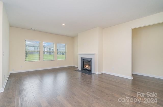 unfurnished living room featuring dark wood-type flooring