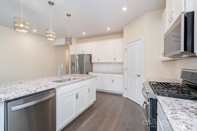 kitchen featuring appliances with stainless steel finishes, pendant lighting, white cabinets, and sink