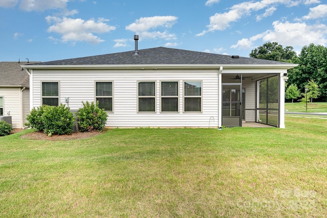 rear view of house with a sunroom and a yard