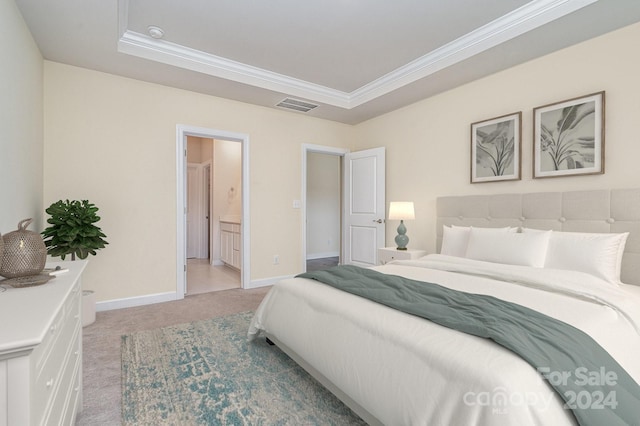 carpeted bedroom with crown molding, a raised ceiling, and ensuite bath