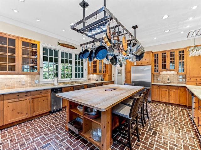 kitchen featuring pendant lighting, sink, backsplash, and built in refrigerator