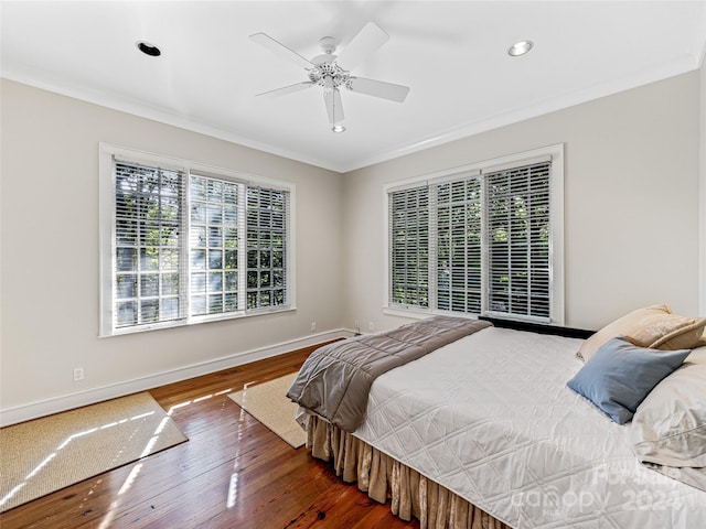 bedroom with dark hardwood / wood-style flooring, ceiling fan, and ornamental molding