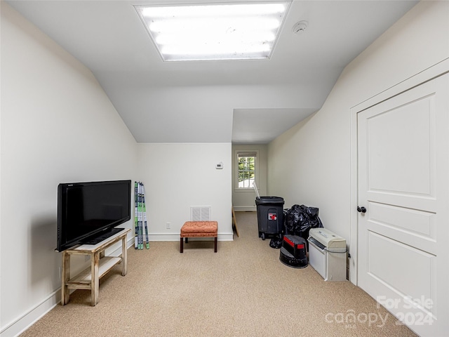 living area with light colored carpet and vaulted ceiling