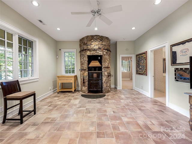 living room with ceiling fan and a fireplace