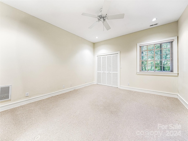 carpeted spare room featuring ceiling fan