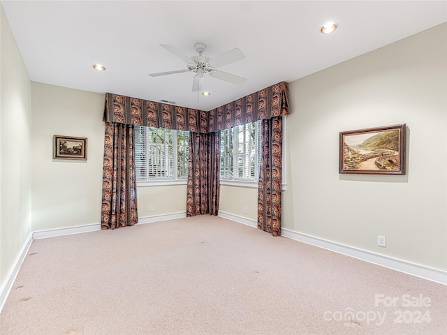 carpeted spare room with ceiling fan