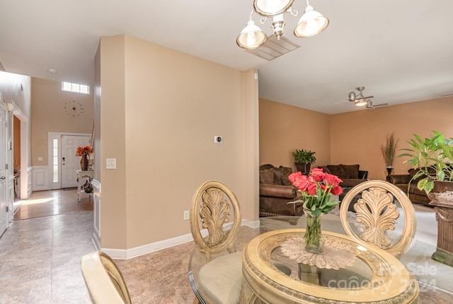 dining room featuring ceiling fan with notable chandelier