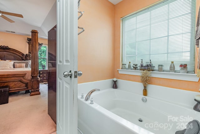 bathroom with vaulted ceiling, ceiling fan, and a tub