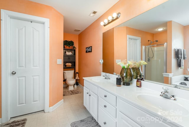 bathroom with toilet, tile patterned floors, a shower with shower door, and vanity