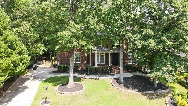 view of property hidden behind natural elements with a front lawn