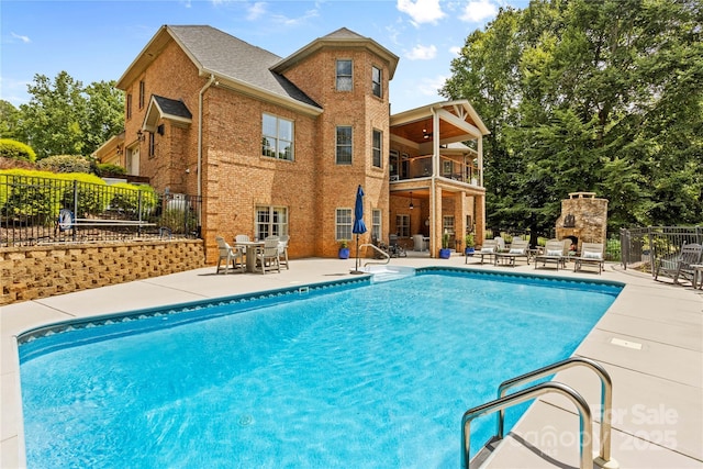 view of swimming pool with a patio and an outdoor fireplace