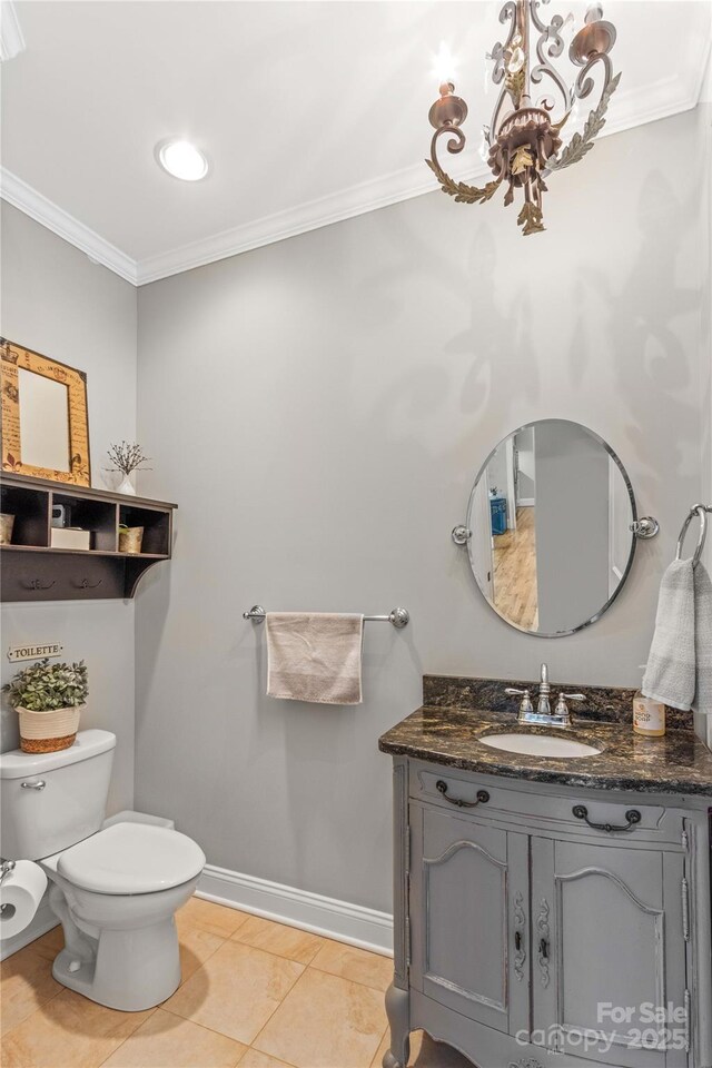 bathroom featuring crown molding, tile patterned flooring, an inviting chandelier, vanity, and toilet