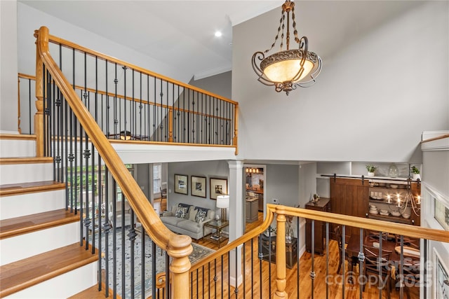 stairway featuring ornate columns and wood-type flooring