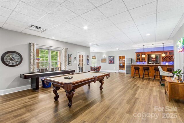 recreation room with hardwood / wood-style floors, pool table, and bar area