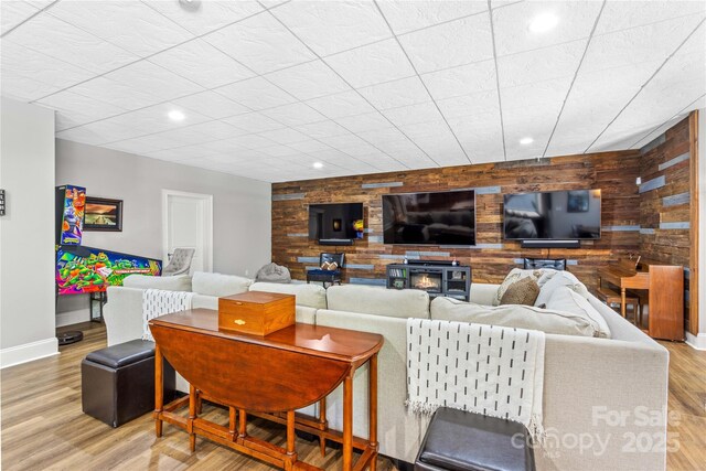 living room featuring light wood-type flooring and wooden walls