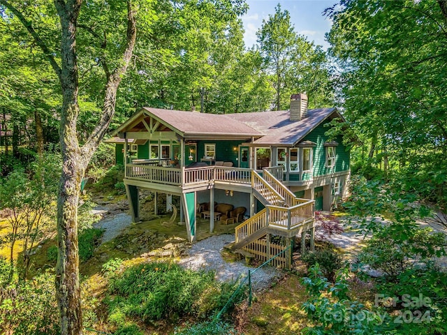 rear view of house featuring a wooden deck