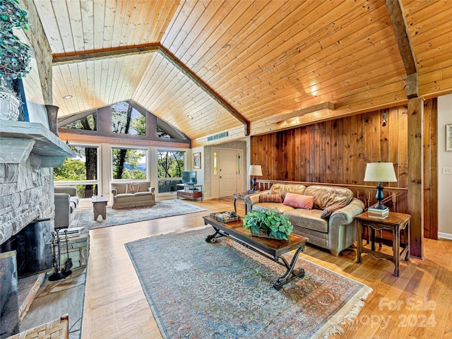 living room featuring a stone fireplace, wooden walls, wooden ceiling, and light hardwood / wood-style floors