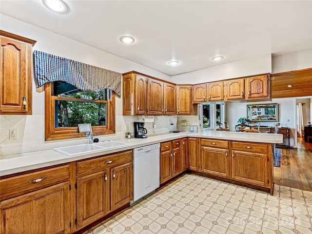 kitchen with dishwasher, decorative backsplash, kitchen peninsula, and sink