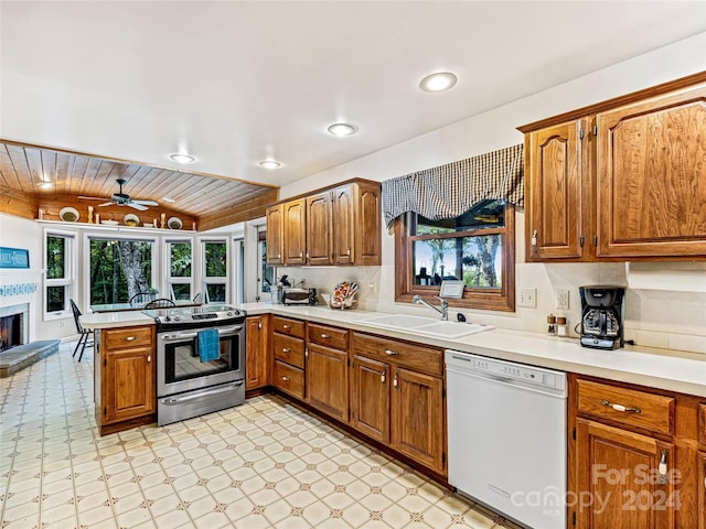 kitchen with a wealth of natural light, ceiling fan, sink, white dishwasher, and stainless steel electric stove