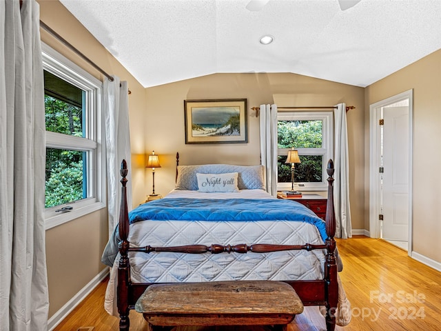 bedroom featuring hardwood / wood-style floors, a textured ceiling, ceiling fan, and lofted ceiling