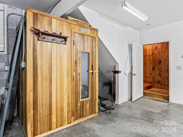 interior space featuring wood walls and concrete flooring