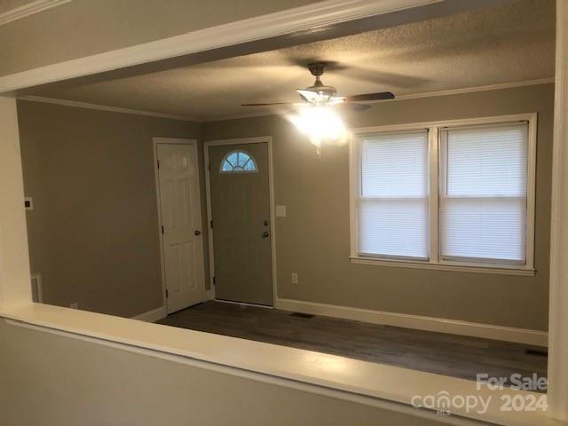 entryway with a textured ceiling, ceiling fan, and ornamental molding