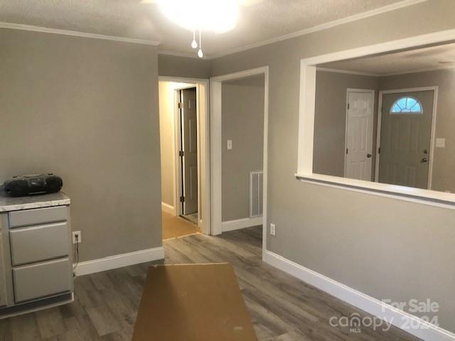 interior space with hardwood / wood-style flooring and ornamental molding