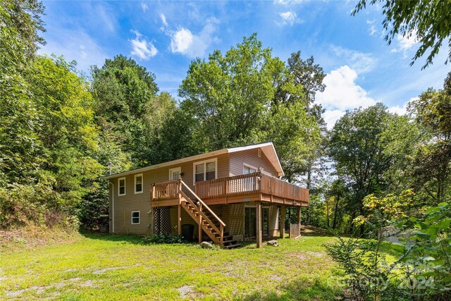 back of property featuring a lawn and a deck