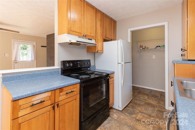 kitchen featuring stone finish flooring, baseboards, under cabinet range hood, brown cabinets, and black electric range