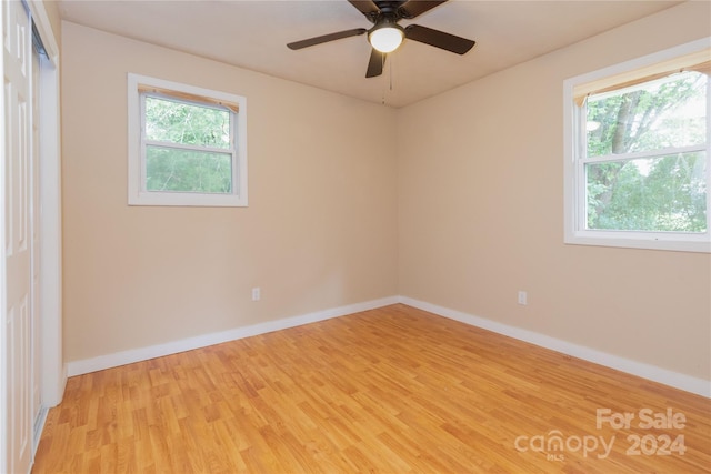 unfurnished room featuring light hardwood / wood-style flooring, a wealth of natural light, and ceiling fan