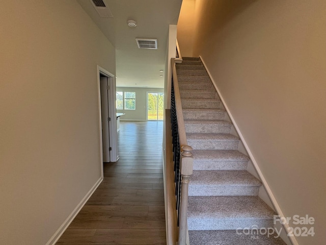 staircase with hardwood / wood-style floors