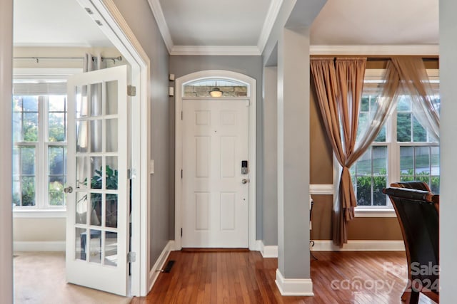 entrance foyer featuring crown molding and hardwood / wood-style flooring