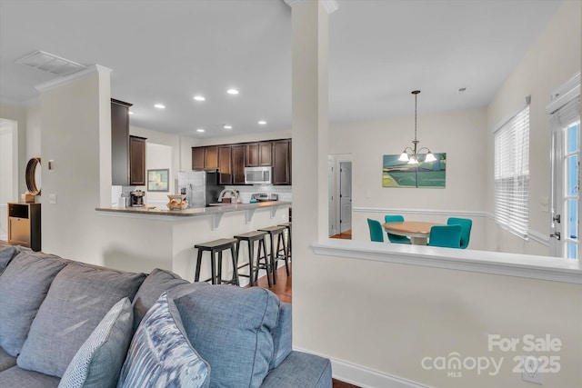 living room with dark hardwood / wood-style flooring and crown molding