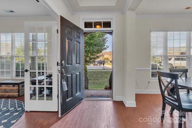 foyer with a wealth of natural light, crown molding, and hardwood / wood-style flooring