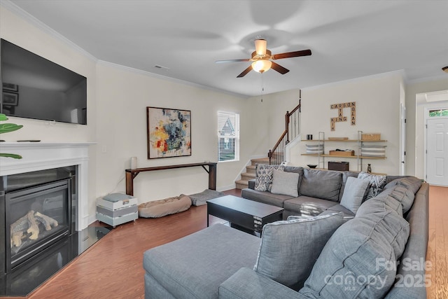 living room with ceiling fan, crown molding, and hardwood / wood-style flooring