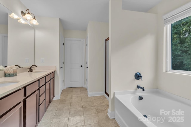 bathroom with a bathing tub, vanity, and tile patterned floors