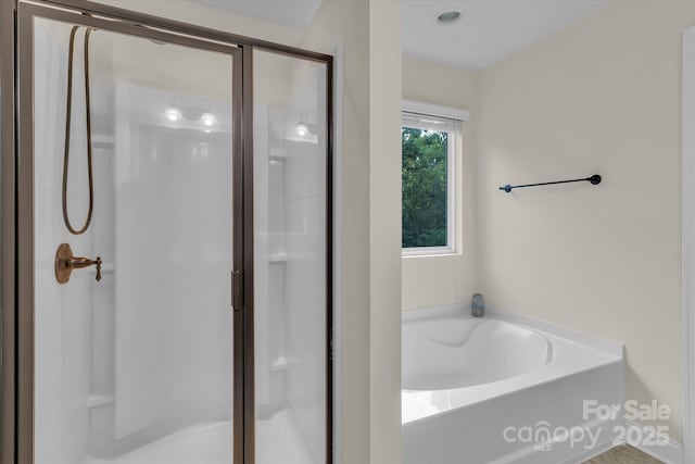 bathroom featuring separate shower and tub