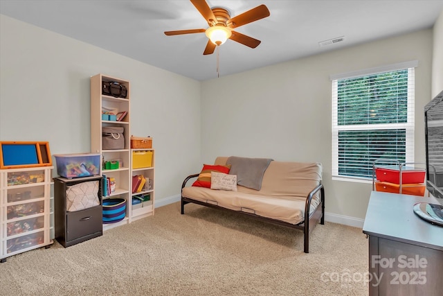 living area featuring carpet floors and ceiling fan