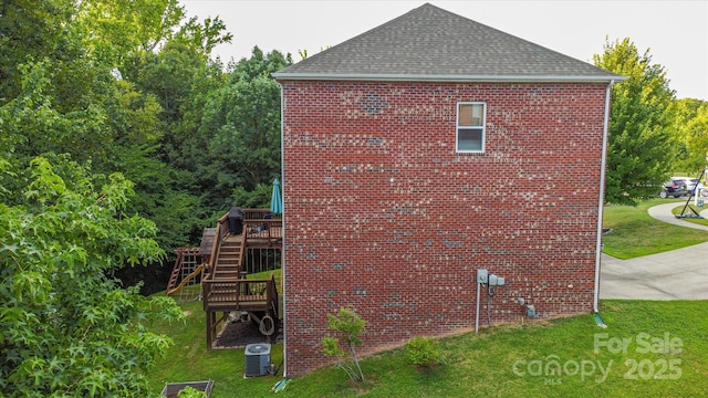 view of home's exterior featuring a lawn, a deck, and central AC