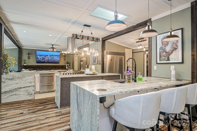 kitchen with light stone countertops, pendant lighting, stainless steel appliances, a kitchen breakfast bar, and kitchen peninsula