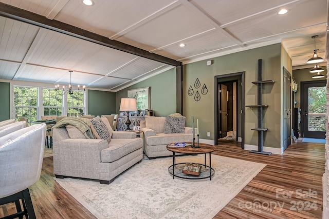 living room with a chandelier, lofted ceiling, and hardwood / wood-style flooring