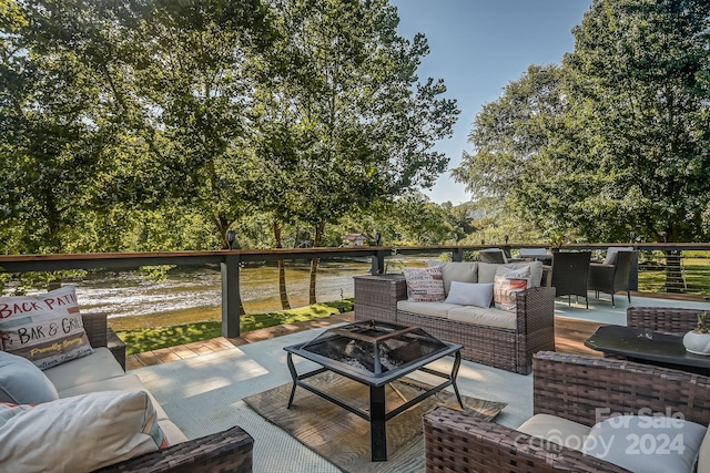 view of patio / terrace with a water view and an outdoor living space with a fire pit