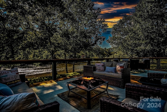 patio terrace at dusk featuring an outdoor living space with a fire pit