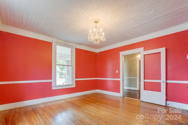 unfurnished room featuring wood-type flooring and a notable chandelier