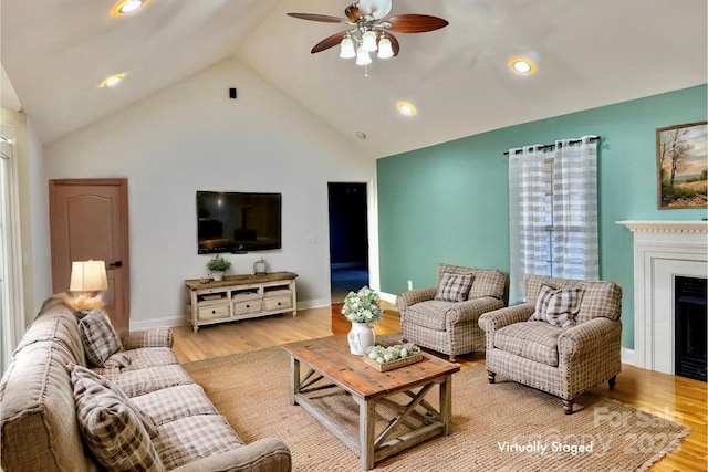 living room featuring high vaulted ceiling, ceiling fan, and light wood-type flooring