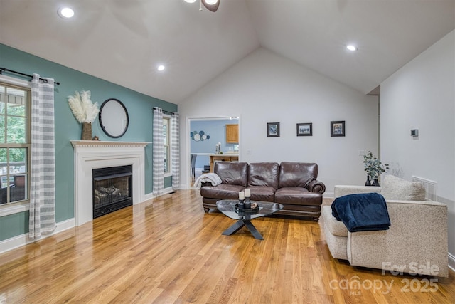 living room with high vaulted ceiling and light hardwood / wood-style floors