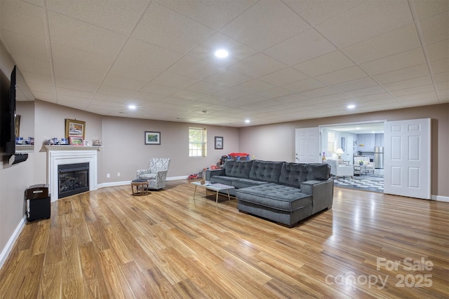 living room with a drop ceiling and light hardwood / wood-style floors