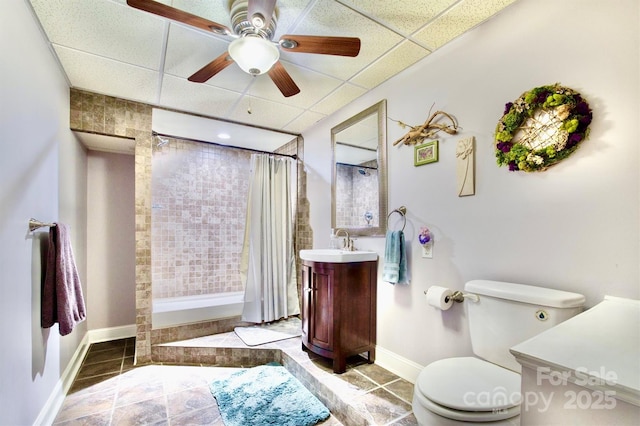 bathroom featuring a paneled ceiling, ceiling fan, vanity, a shower with curtain, and toilet